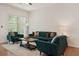 Elegant living room featuring hardwood floors, a teal sofa, and bright, natural light at 993 Everest, Clermont, FL 34711