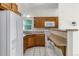 Galley kitchen featuring warm wood cabinetry, white appliances, and breakfast bar at 1102 Whitewood Dr, Deltona, FL 32725