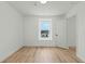 Clean bedroom with wood-look floors, window, and an entry door at 1143 Seedorf Dr, Winter Haven, FL 33881