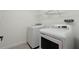 Bright laundry room featuring modern white washer and dryer, and overhead wire shelving for ample storage at 1143 Seedorf Dr, Winter Haven, FL 33881