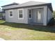Back of a modern home with a covered patio, surrounded by a well-maintained lawn at 1359 Greenfield Loop, Kissimmee, FL 34747