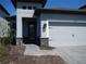Close up on the charming single-Gathering home featuring a gray exterior with decorative front door at 1359 Greenfield Loop, Kissimmee, FL 34747