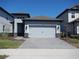 Charming single-Gathering home featuring a gray exterior, gray driveway, and a two-car garage at 1359 Greenfield Loop, Kissimmee, FL 34747
