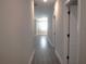Hallway with wood-look floors and neutral walls, leading to various rooms in the home at 1359 Greenfield Loop, Kissimmee, FL 34747