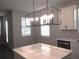 Modern kitchen island featuring quartz countertop and stylish lighting at 1359 Greenfield Loop, Kissimmee, FL 34747