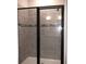 Modern shower featuring gray tile and sleek black framed glass door at 1359 Greenfield Loop, Kissimmee, FL 34747