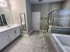 Bathroom with double sink vanity, tiled floors, a soaking tub, and a glass shower enclosure at 14419 Magnolia Ridge Loop, Winter Garden, FL 34787