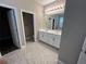 Bathroom with a double vanity, tiled floors, and separate toilet room at 14419 Magnolia Ridge Loop, Winter Garden, FL 34787