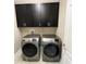 Laundry room with modern washer and dryer machines and upper cabinets at 14419 Magnolia Ridge Loop, Winter Garden, FL 34787