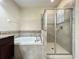 Bathroom features soaking tub, glass shower, and vanity with dark cabinets at 15129 Driftwood Bend St, Winter Garden, FL 34787