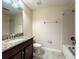 Neutral bathroom features granite vanity, framed mirror, tile floors, and shower-tub combo at 15129 Driftwood Bend St, Winter Garden, FL 34787