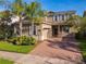Two-story home with a brick-paved driveway, well-manicured landscaping, and a two-car garage at 15129 Driftwood Bend St, Winter Garden, FL 34787