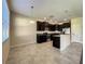 Open kitchen features dark cabinetry, stainless steel appliances, tile flooring, and a breakfast bar at 15129 Driftwood Bend St, Winter Garden, FL 34787