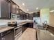 Well-equipped kitchen features stainless steel appliances, granite counters, and dark wood cabinets at 15129 Driftwood Bend St, Winter Garden, FL 34787