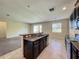 Open floor plan with a modern kitchen overlooking the living area with dark cabinets and stainless appliances at 15129 Driftwood Bend St, Winter Garden, FL 34787