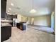 Open floor plan with a modern kitchen overlooking the living area with dark cabinets and stainless appliances at 15129 Driftwood Bend St, Winter Garden, FL 34787