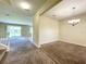 Open-concept living room with carpeted floors, a view of the backyard, and a dining area at 15129 Driftwood Bend St, Winter Garden, FL 34787