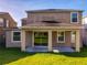 Home exterior showcases a covered patio with lush green grass at 15129 Driftwood Bend St, Winter Garden, FL 34787