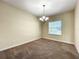 Inviting room with neutral walls, carpet flooring, a chandelier, and a window at 15129 Driftwood Bend St, Winter Garden, FL 34787