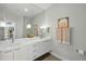Bathroom featuring double sinks with white cabinetry and a large mirror at 1645 Retreat Cir, Clermont, FL 34714
