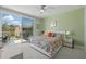 Bright bedroom with a floral bedspread and sliding glass doors leading to a balcony at 1645 Retreat Cir, Clermont, FL 34714