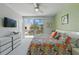 Bright bedroom featuring a colorful floral-patterned bedspread and access to a private balcony at 1645 Retreat Cir, Clermont, FL 34714