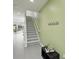 Bright entryway featuring neutral gray floors, a staircase with white railing, and a coat rack at 1645 Retreat Cir, Clermont, FL 34714