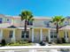 Inviting two-story townhome showcasing a well-manicured lawn and two palm trees at 1645 Retreat Cir, Clermont, FL 34714