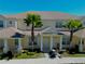 Charming two-story townhome featuring a well-manicured lawn and two palm trees at 1645 Retreat Cir, Clermont, FL 34714