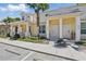 Charming townhome with bright yellow exterior, white columns, and well-maintained landscaping at 1645 Retreat Cir, Clermont, FL 34714