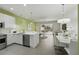 Open-concept kitchen with white cabinets and stainless appliances, flowing into the dining and living areas at 1645 Retreat Cir, Clermont, FL 34714