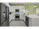 Modern kitchen with sleek white cabinets, stainless steel appliances, and neutral countertops at 1645 Retreat Cir, Clermont, FL 34714