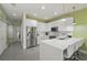 Modern kitchen featuring stainless steel appliances and a sleek white countertop island with bar stool seating at 1645 Retreat Cir, Clermont, FL 34714