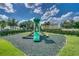 Community playground with a green slide and lush landscaping, ideal for Gathering fun at 1645 Retreat Cir, Clermont, FL 34714