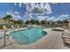 Community pool area with lounge chairs and palm trees, offering a resort-like experience at 1645 Retreat Cir, Clermont, FL 34714