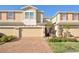 Townhome with two stories, charming curb appeal, beige exterior and a brick driveway at 1737 Kato Way, Kissimmee, FL 34744