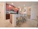 Eat-in kitchen features an island with bar stool seating, granite countertops, and warm cabinetry at 1737 Kato Way, Kissimmee, FL 34744