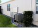 Side view of home with installed HVAC equipment and landscaping at 17418 Blazing Star Cir, Clermont, FL 34714