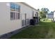 Side view of home showing the installed HVAC, water filter, and storage battery equipment at 17418 Blazing Star Cir, Clermont, FL 34714