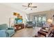 Comfortable living room with a cozy fireplace, wood flooring, and sliding glass doors to the screened in lanai at 17418 Blazing Star Cir, Clermont, FL 34714