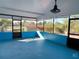 Indoor sunroom, with a bright blue floor and a view of the trees outside at 181 Whisper Wood Ct, Kissimmee, FL 34743