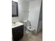 Cozy bathroom featuring a white toilet, vanity, sink, dark brown cabinets, and a mirror at 1926 Cattleya Dr, Kissimmee, FL 34741