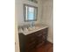 Bathroom featuring granite countertops, dark cabinets, and a framed mirror at 1926 Cattleya Dr, Kissimmee, FL 34741