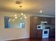 Kitchen featuring dark wood cabinets, a new white range and microwave and updated light fixture at 1926 Cattleya Dr, Kissimmee, FL 34741