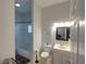 A well-lit bathroom featuring a toilet, vanity, mirror, and bathtub with white tiling at 204 New Providence # 10104, Davenport, FL 33897