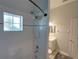 This bathroom features a tiled bathtub with shower, window and a view into the vanity area at 204 New Providence # 10104, Davenport, FL 33897
