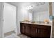 Bright bathroom features a double sink vanity with dark wood cabinets and tile flooring at 2129 Stillwood Way, St Cloud, FL 34771