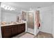 Bright bathroom with a double sink vanity with dark wood cabinets, glass-enclosed shower, and tile flooring at 2129 Stillwood Way, St Cloud, FL 34771