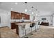 Modern kitchen with granite countertops, tile backsplash, and island with bar seating open to the living room at 2129 Stillwood Way, St Cloud, FL 34771