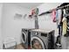 Well-organized laundry room with modern washer and dryer, storage shelves, and hanging rack at 2129 Stillwood Way, St Cloud, FL 34771